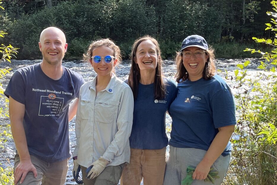 Volunteers smile as they stand near improved river access. 