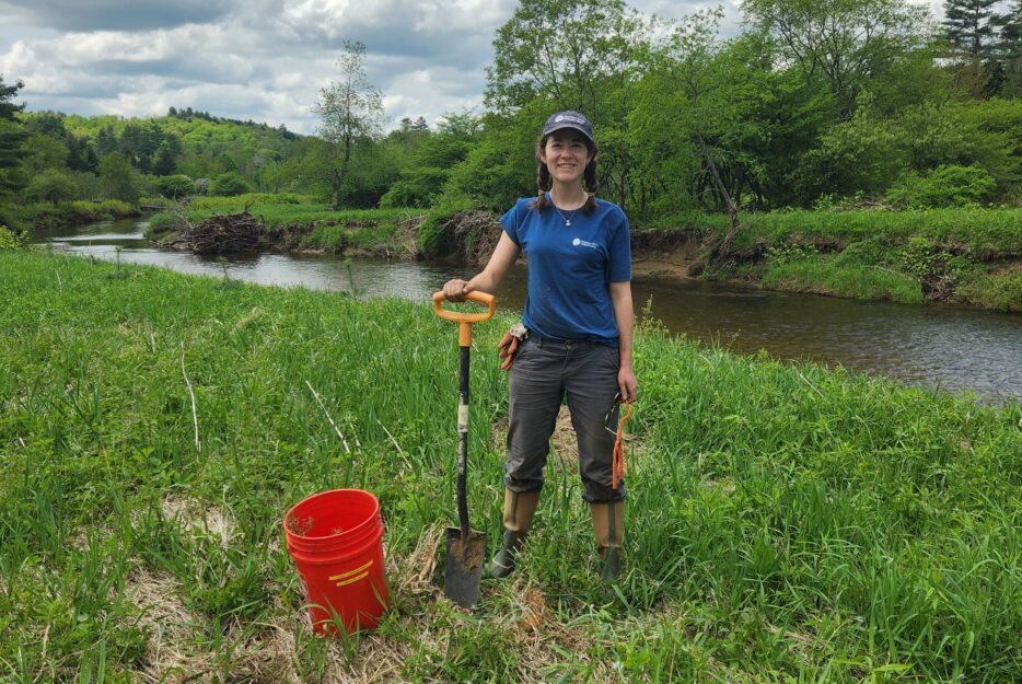 group of volunteer tree planters in a field tree planting to protect and restore rivers
