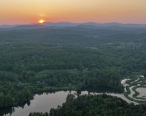 Kingsbury Branch at sunset from North Montpelier by John Joy Kingsbury Branch river from above green trees and mountains at sunset in North Montpelier at sunset