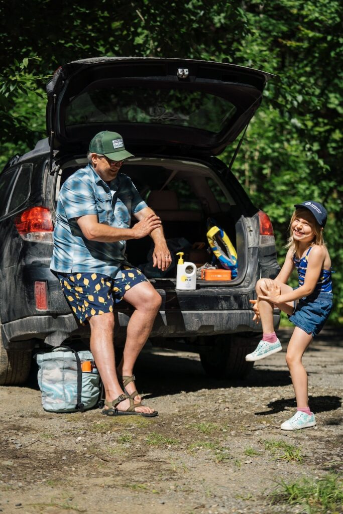 Father and child putting on sunscreen for safe river recreation Pc Evan Kay