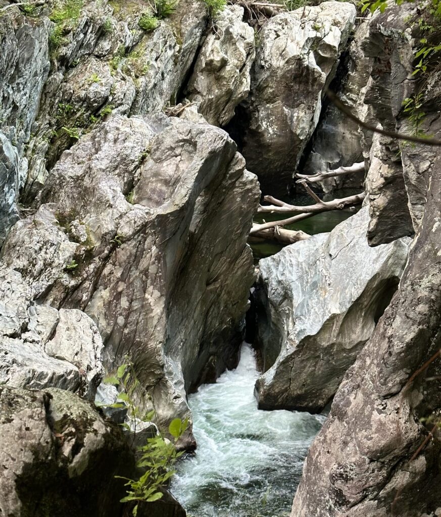 Fast-moving, foamy water rushes through Huntington Gorge, creating strong currents and highly aerated water around rocks and the waterfall that make this swimming hole extremely dangerous.