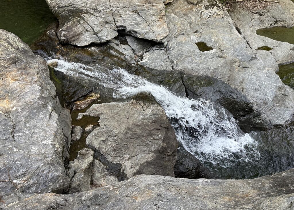 Bolton Potholes waterfall flowing over swimming hole in Bolton, Vermont