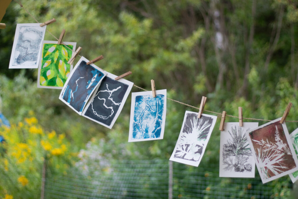Colorful finished monoprints drying on a rainy day during the workshop.